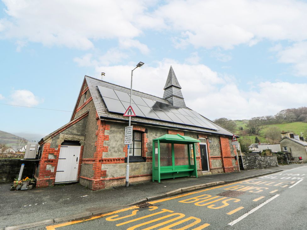 A building with solar panels and a bus stop at Yr Hen Ysgoldy in 