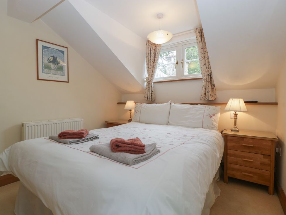 A bedroom with a bed and two lamps at Wren Cottage in Ross-on-Wye