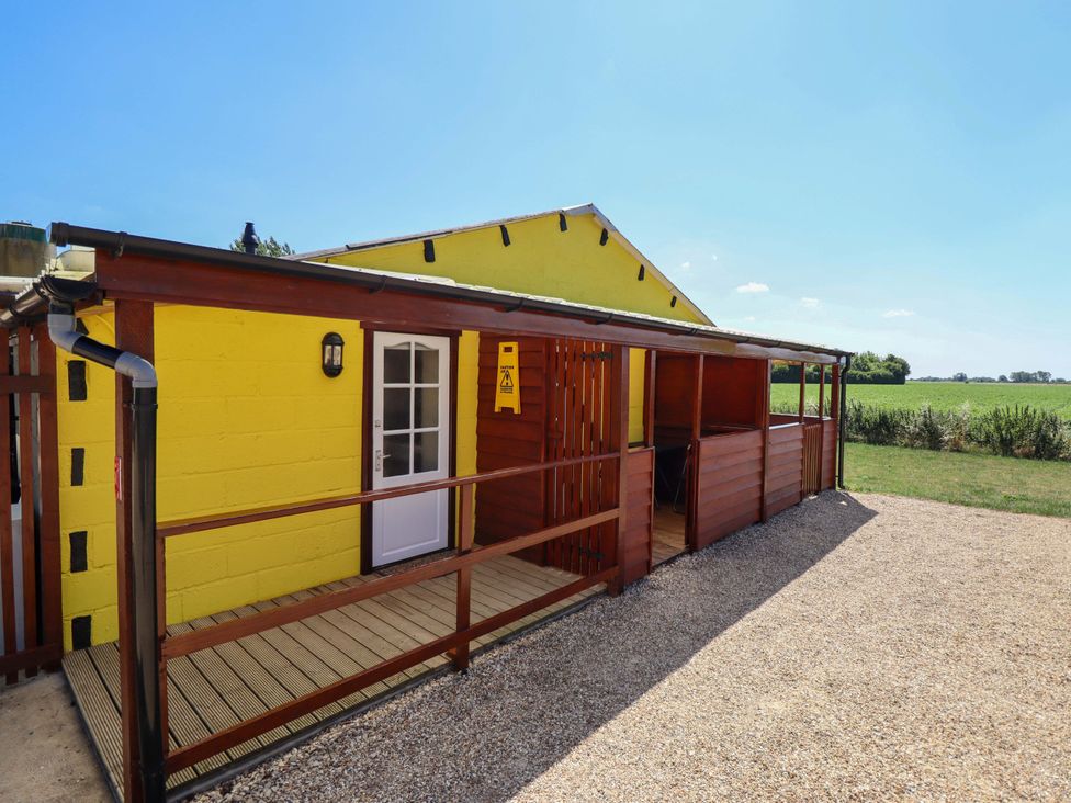 A house with a wooden deck and surrounding grass at Dakota