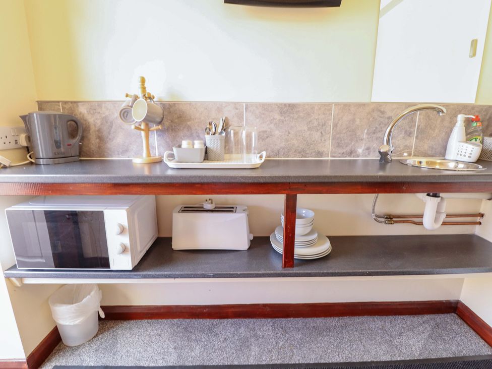 A kitchen with kettle, microwave, toaster, and sink at Dakota