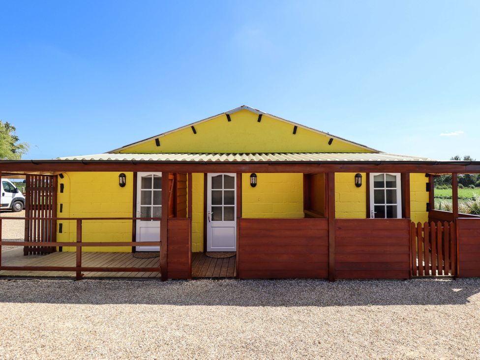 A house with a yellow exterior and wooden front porch at Lancaster in Lincoln