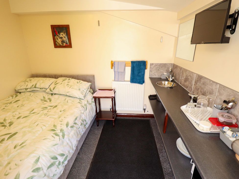 A bedroom with a bed and kitchenette at Lancaster in Lincoln