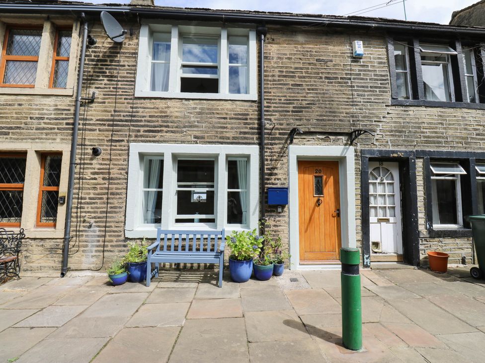 A house front with windows and a door at Winberry Cottage in Haworth
