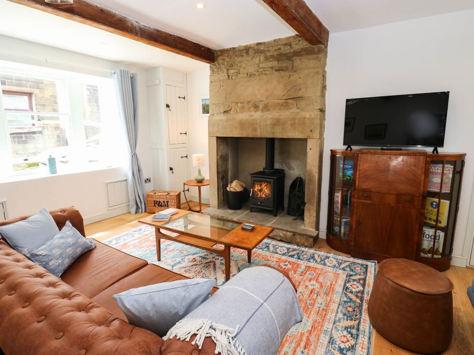 A living room with a fireplace and sofa at Winberry Cottage in Haworth