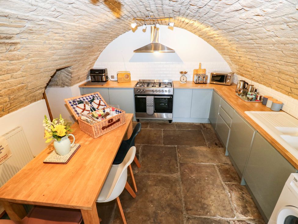 A kitchen with a table and chairs at Winberry Cottage in Haworth