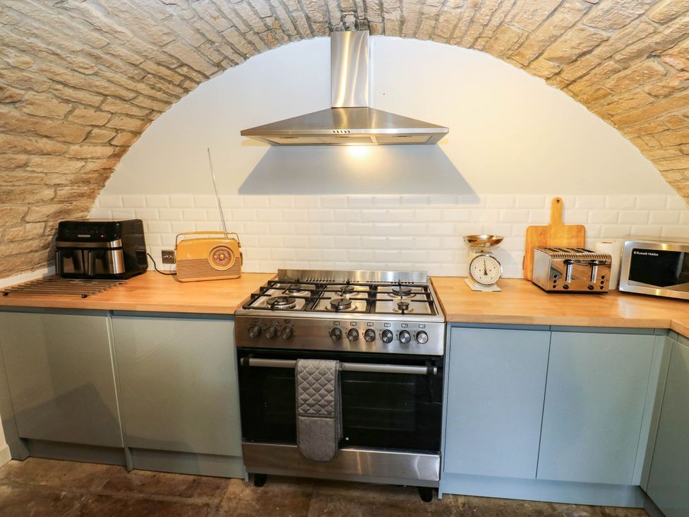 A kitchen with an oven and various appliances at Winberry Cottage Haworth