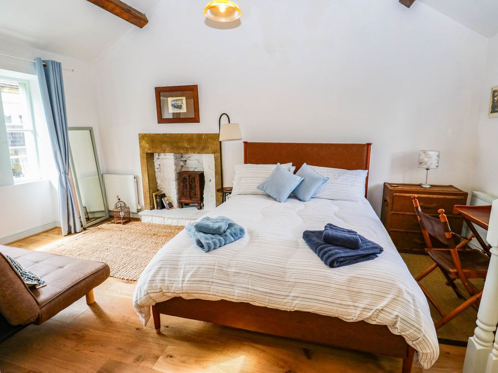 A bedroom with bed and fireplace at Winberry Cottage in Haworth
