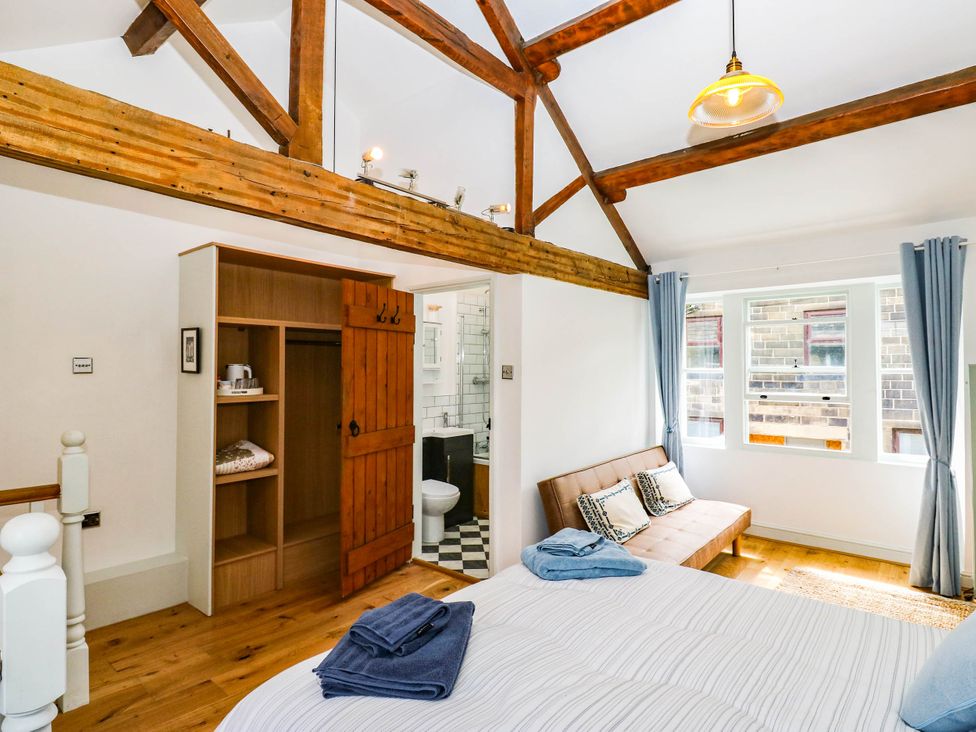 A bedroom with a bed and a wardrobe at Winberry Cottage in Haworth