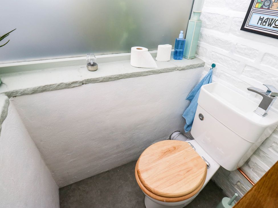 A bathroom with a toilet and sink at Winberry Cottage in Haworth