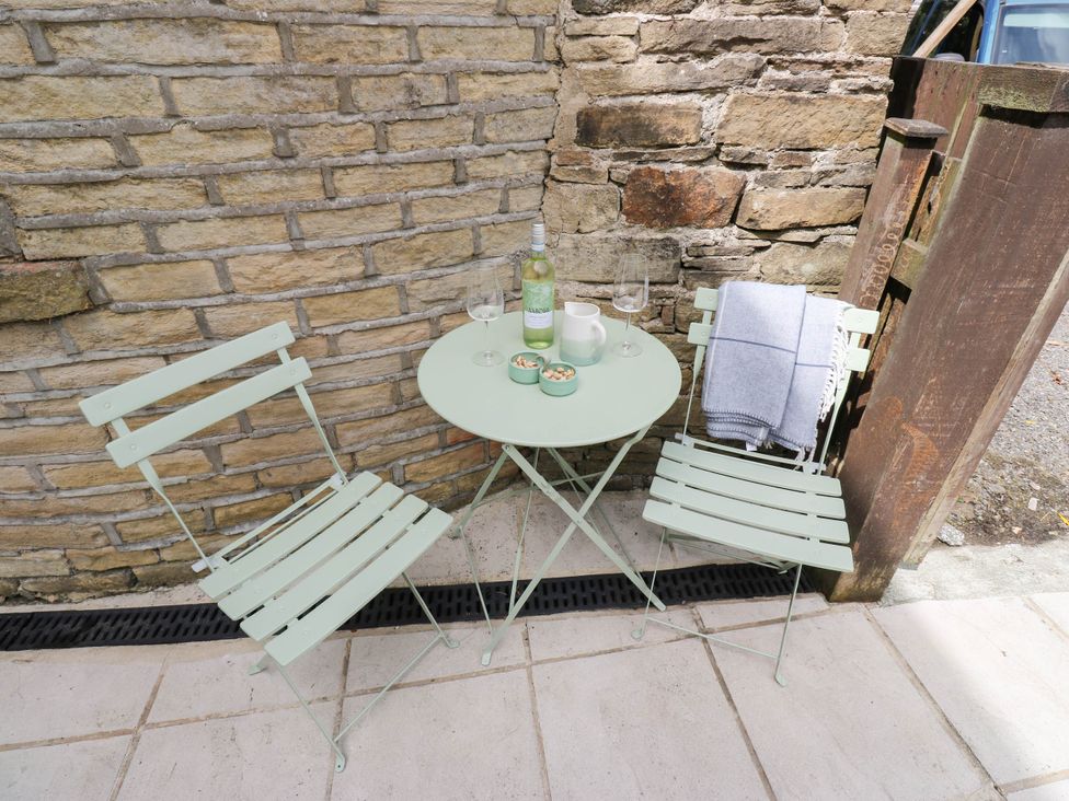An outdoor area with a table and chairs at Winberry Cottage in Haworth