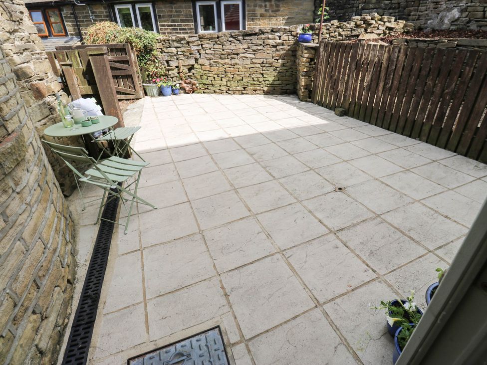 A garden area with a table and chairs at Winberry Cottage in Haworth