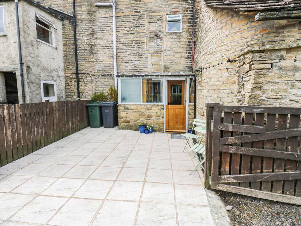 An outdoor area with a door and patio tiles at Winberry Cottage in Haworth