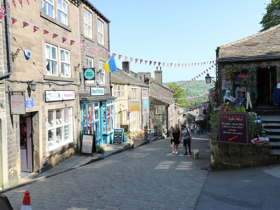 A street with shops and people walking at Winberry Cottage in Haworth