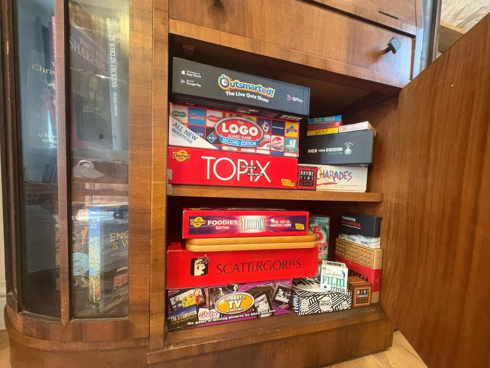 A cabinet with various board games at Winberry Cottage in Haworth