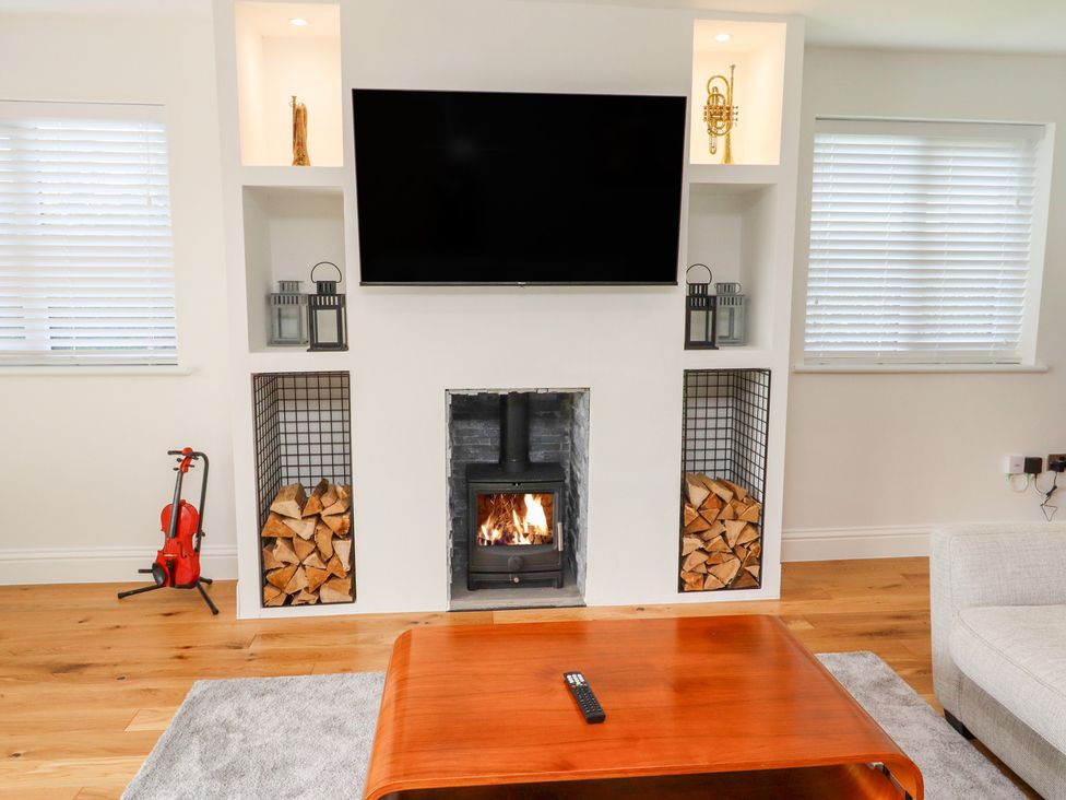 A living room with a fireplace and television at Rose Cottage Dunstan near Embleton