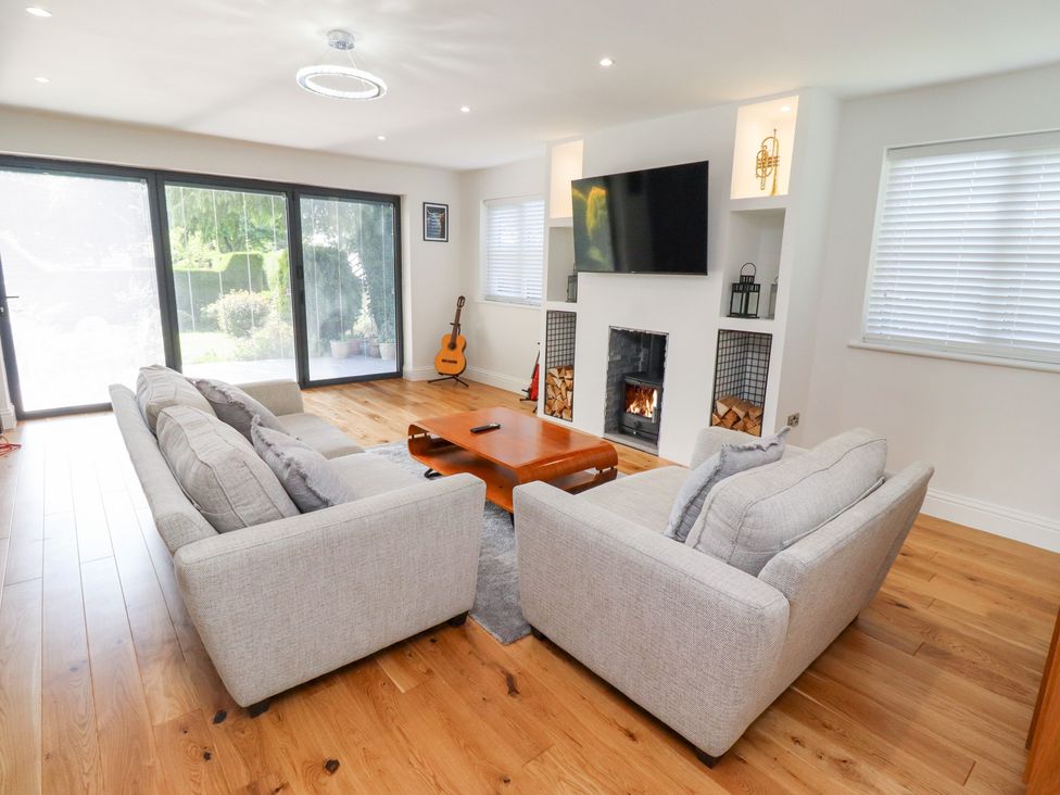 A living room with a guitar and a fireplace at Rose Cottage in Dunstan near Embleton