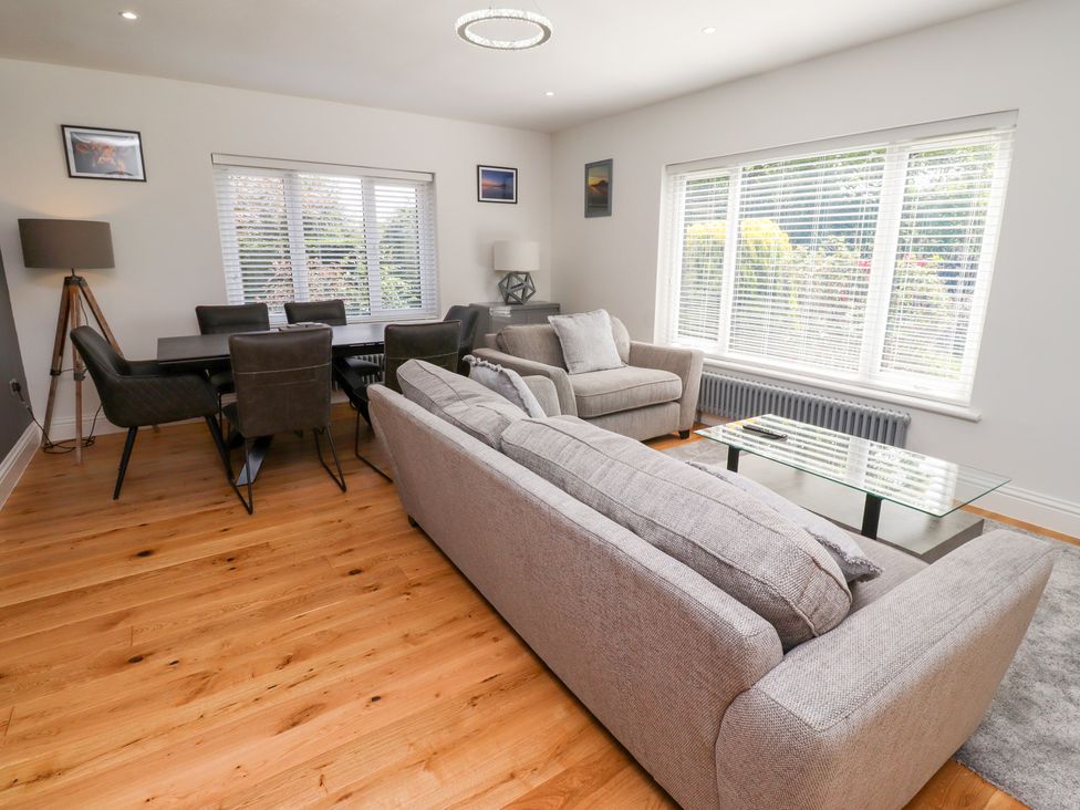 A living room with a sofa and dining table at Rose Cottage Dunstan near Embleton