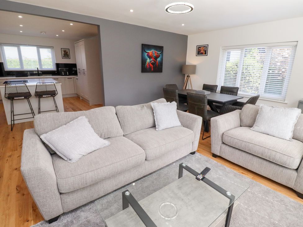 A living room with a sofa and dining area at Rose Cottage Dunstan near Embleton