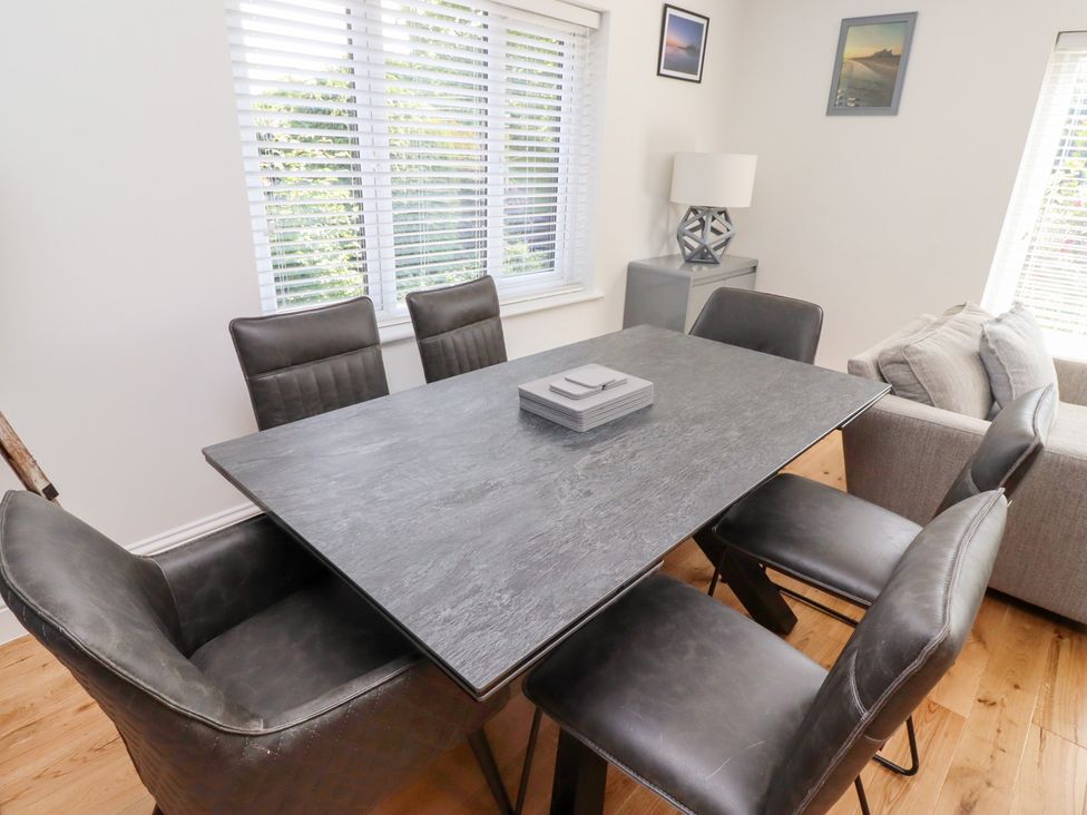 A dining room with a table and chairs at Rose Cottage in Dunstan near Embleton