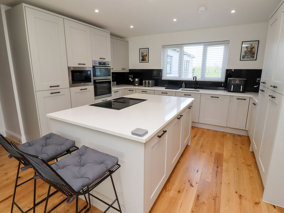 A kitchen with cabinets and an island at Rose Cottage Dunstan near Embleton
