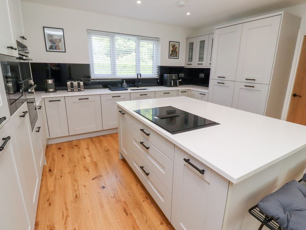 A kitchen with cabinets and appliances at Rose Cottage in Dunstan near Embleton