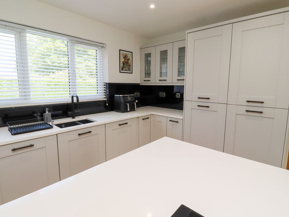 A kitchen with cabinets and a sink at Rose Cottage Dunstan near Embleton