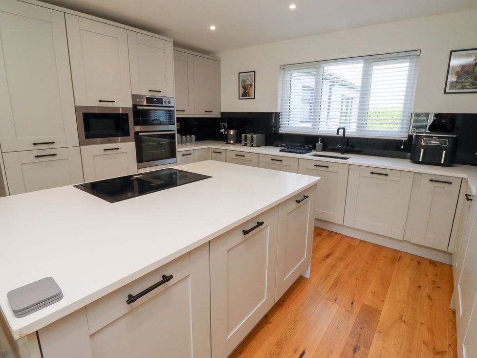 A kitchen with appliances and cabinets at Rose Cottage in Dunstan near Embleton