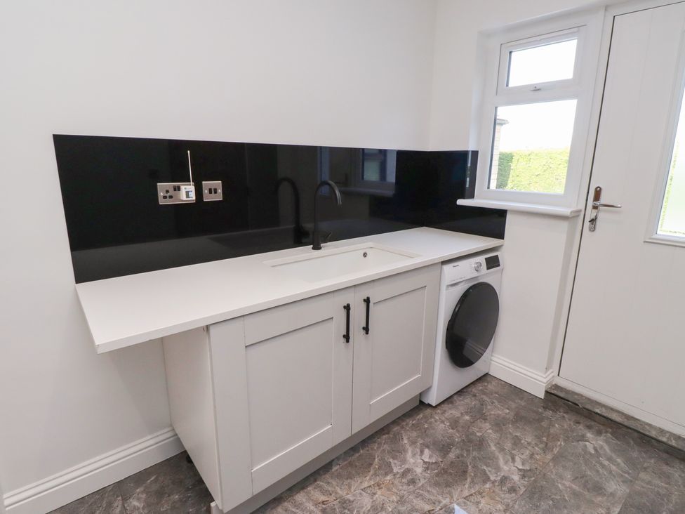 A laundry room with a sink and washing machine at Rose Cottage in Dunstan near Embleton