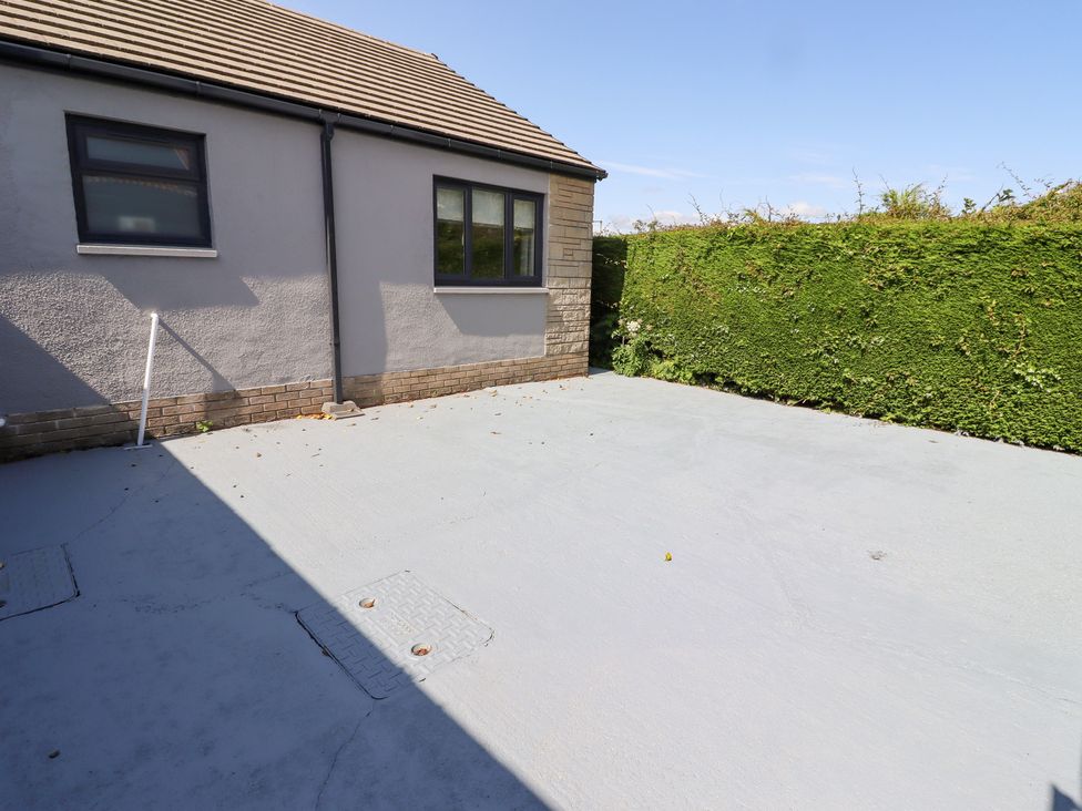 An outdoor area with a house exterior and concrete surface at Rose Cottage in Dunstan near Embleton