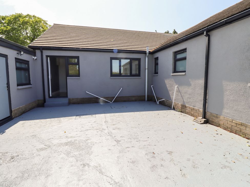 An outdoor area with a building and windows at Rose Cottage in Dunstan near Embleton