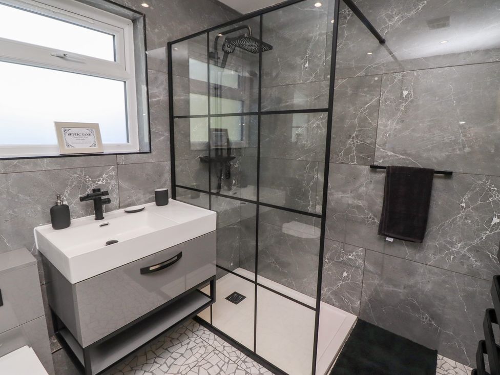 A bathroom with a shower and wash basin at Rose Cottage in Dunstan near Embleton