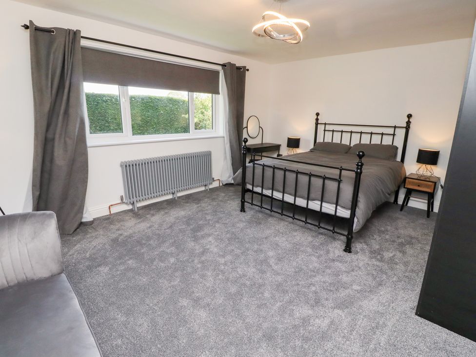 A bedroom with a bed and nightstands at Rose Cottage Dunstan near Embleton