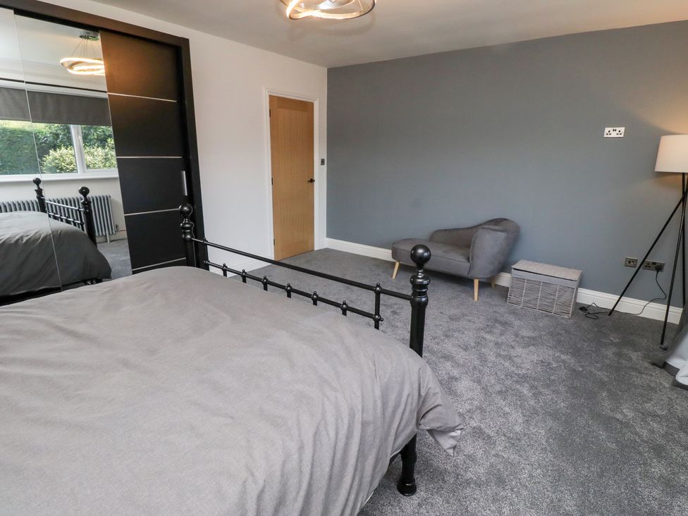A bedroom with a bed and chair at Rose Cottage in Dunstan near Embleton