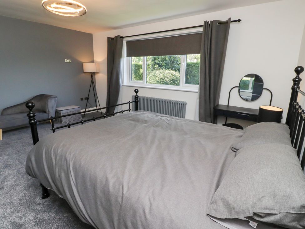 A bedroom with a bed and a sofa at Rose Cottage in Dunstan near Embleton