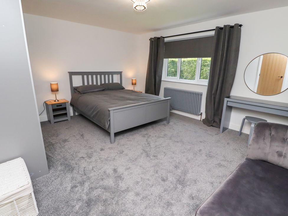 A bedroom with a bed and nightstand at Rose Cottage in Dunstan near Embleton