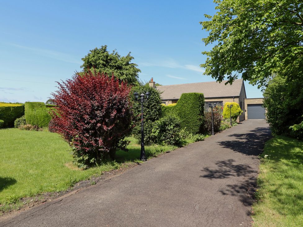 A house with a driveway and garden at Rose Cottage in Dunstan near Embleton