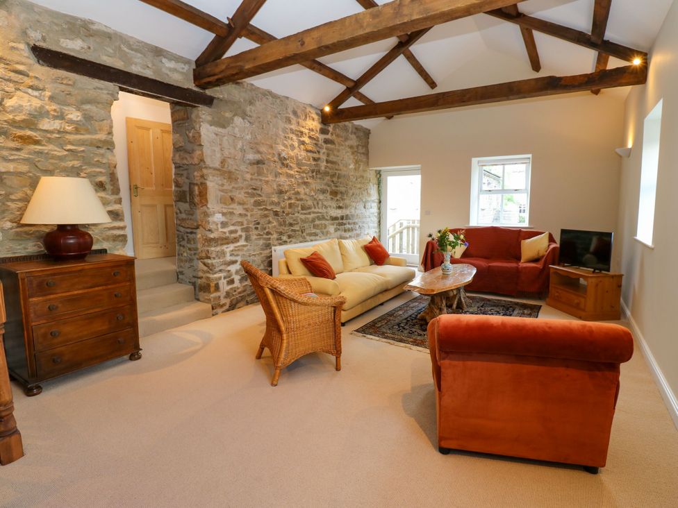 A living room with a sofa and coffee table at High Meadow Barn Thornton Rust near Bainbridge