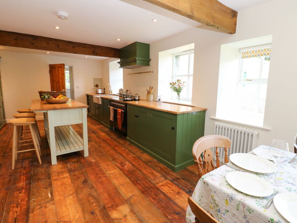A kitchen with wooden floors and green cabinetry at High Meadow Barn Thornton Rust near Bainbridge