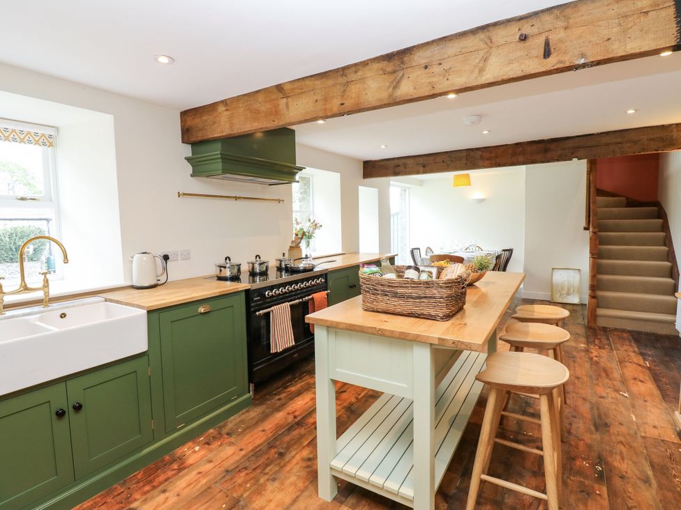 A kitchen with a sink and stove with cookware at High Meadow Barn Thornton Rust near Bainbridge