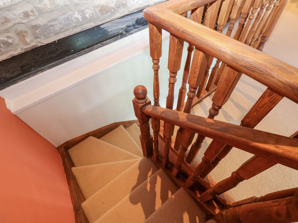A staircase with a wooden handrail and carpet at High Meadow Barn Thornton Rust near Bainbridge