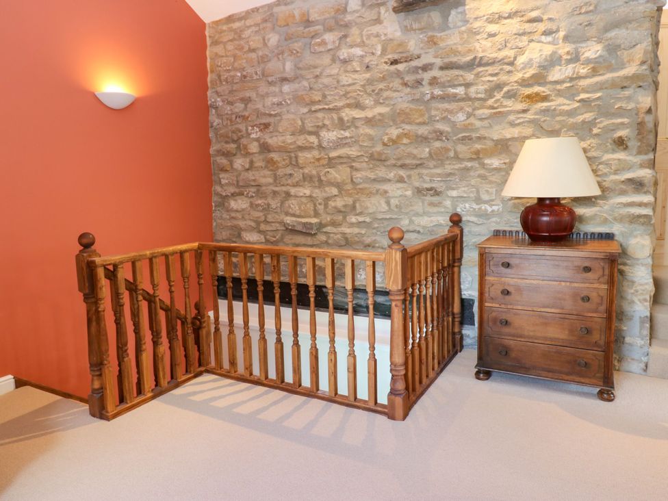A landing area with a wooden railing and lamp at High Meadow Barn Thornton Rust near Bainbridge