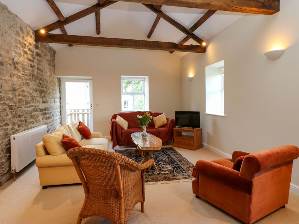 A living room with a sofa and a table at High Meadow Barn in Thornton Rust near Bainbridge