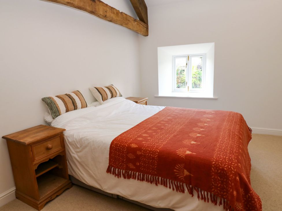 A bedroom with a bed and bedside tables at High Meadow Barn Thornton Rust near Bainbridge
