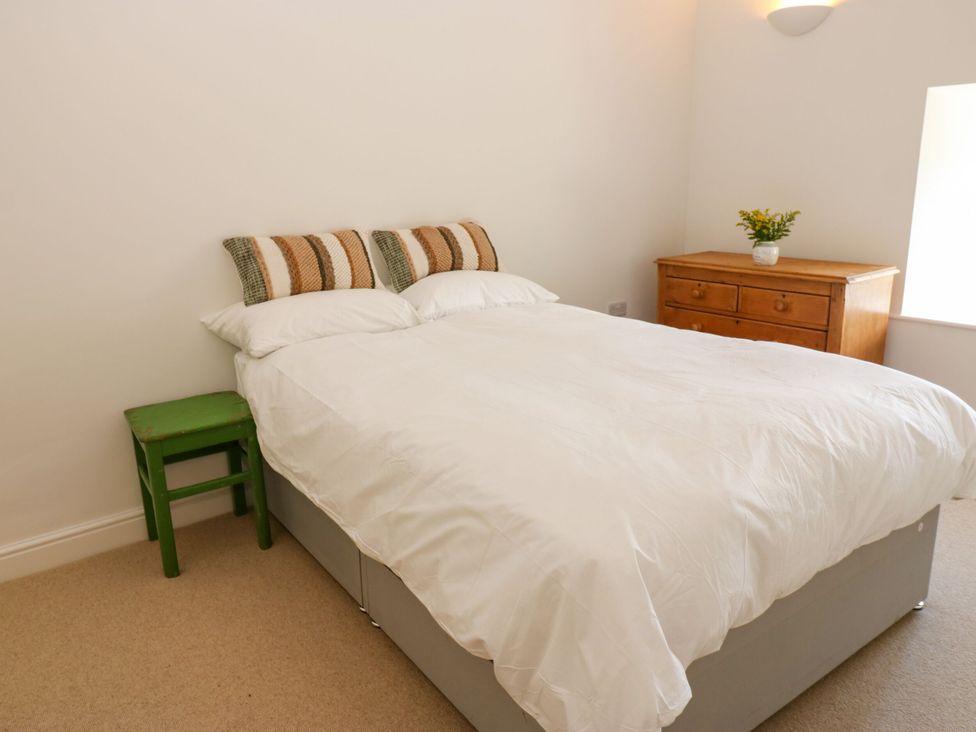 A bedroom with a bed and dresser at High Meadow Barn Thornton Rust near Bainbridge