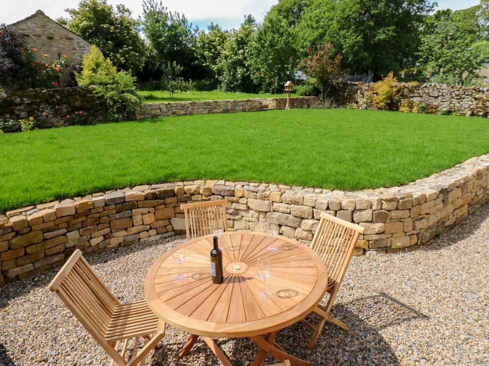 A garden with a table and chairs at High Meadow Barn Thornton Rust near Bainbridge