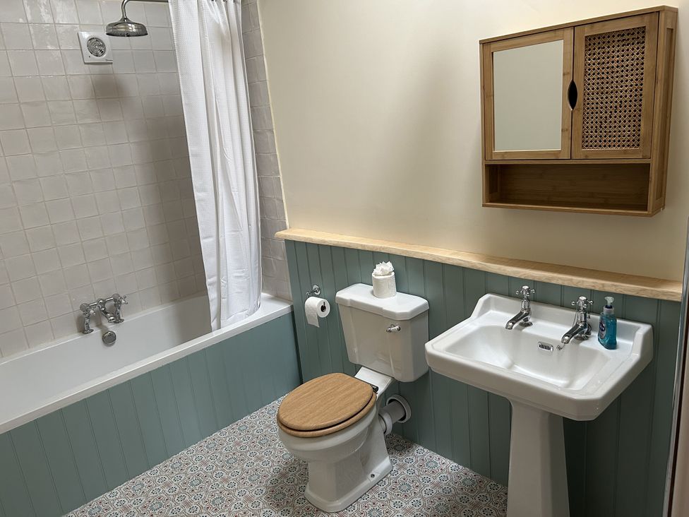 A bathroom with a bathtub, toilet, and sink at High Meadow Barn Thornton Rust near Bainbridge