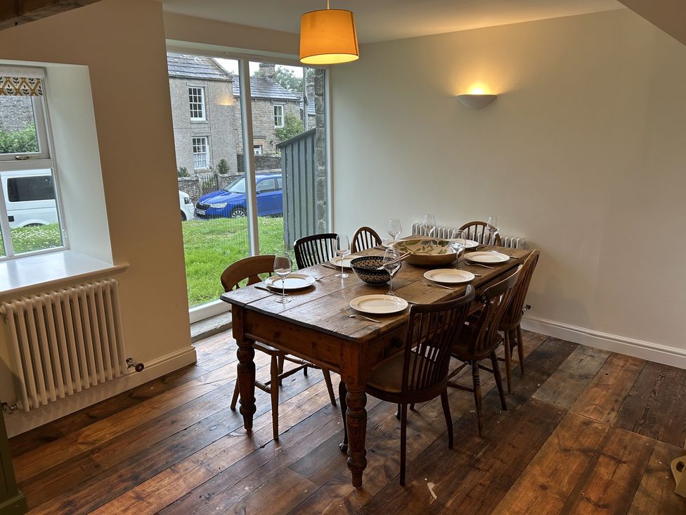 A dining room with a wooden table and chairs at High Meadow Barn Thornton Rust near Bainbridge