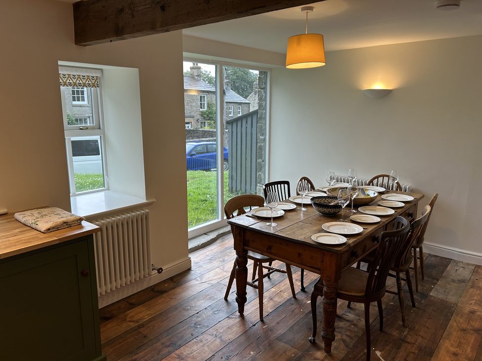 A dining room with a wooden table set for meals at High Meadow Barn Thornton Rust near Bainbridge