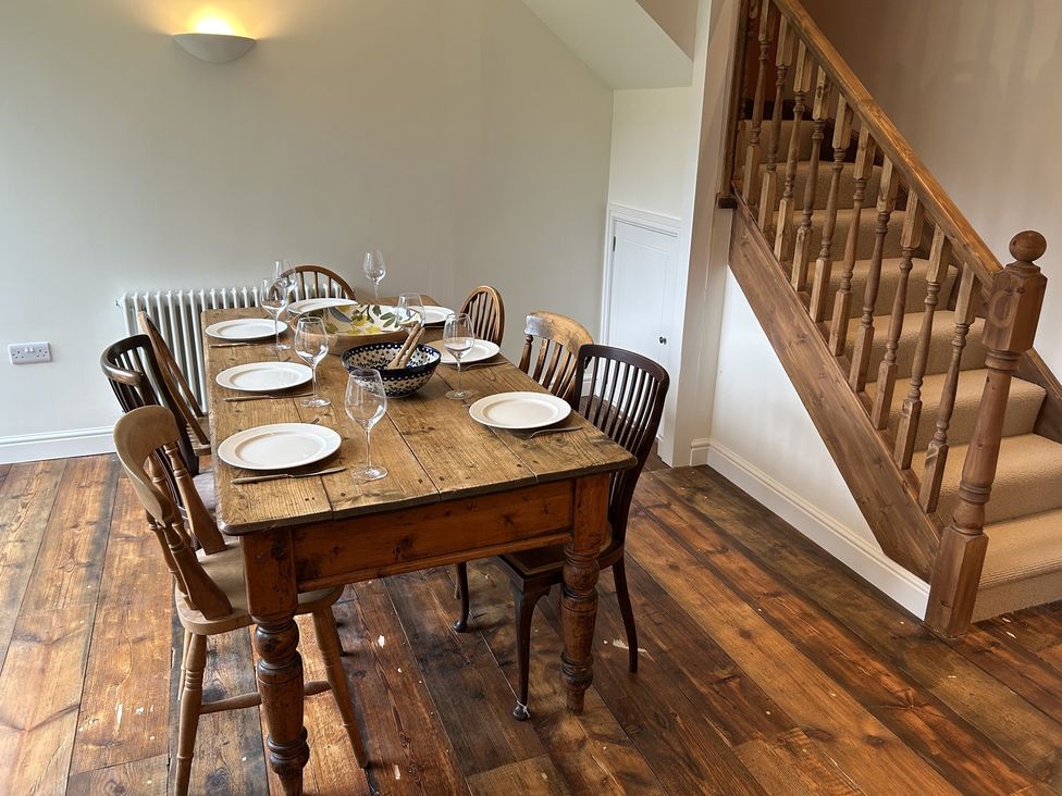 A dining room with a table set for a meal at High Meadow Barn Thornton Rust near Bainbridge