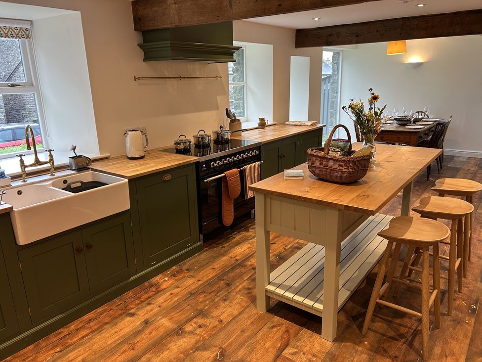 A kitchen with a sink, stove, and wooden island at High Meadow Barn Thornton Rust near Bainbridge